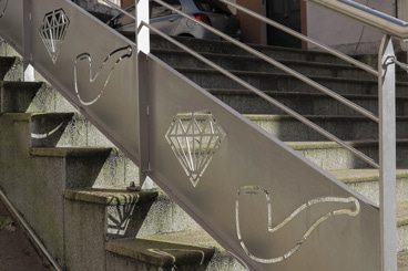 Rambarde en fer forgé illustrant une pipe et une diamant dans Saint-Claude